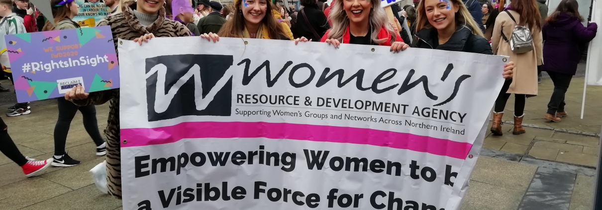 Young women holding WRDA's banner at International Women's Day 2020.