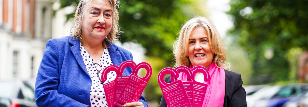 Katherine Robertson and Paula Murray with waterproof cards that hang in the shower to give instructions on the best procedure for breast self-examination.