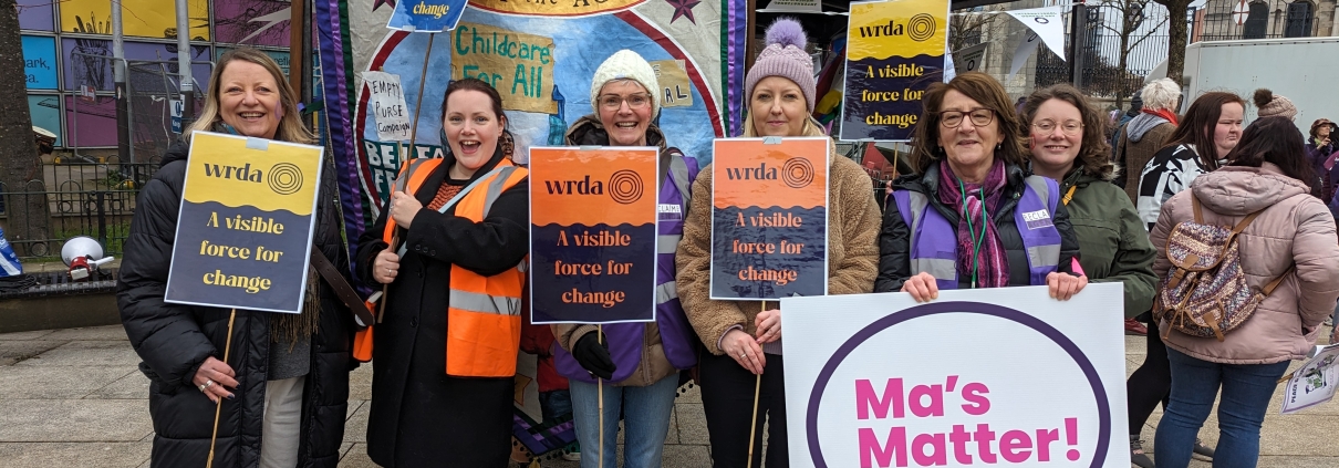 WRDA staff with banners at IWD 2024 rally.